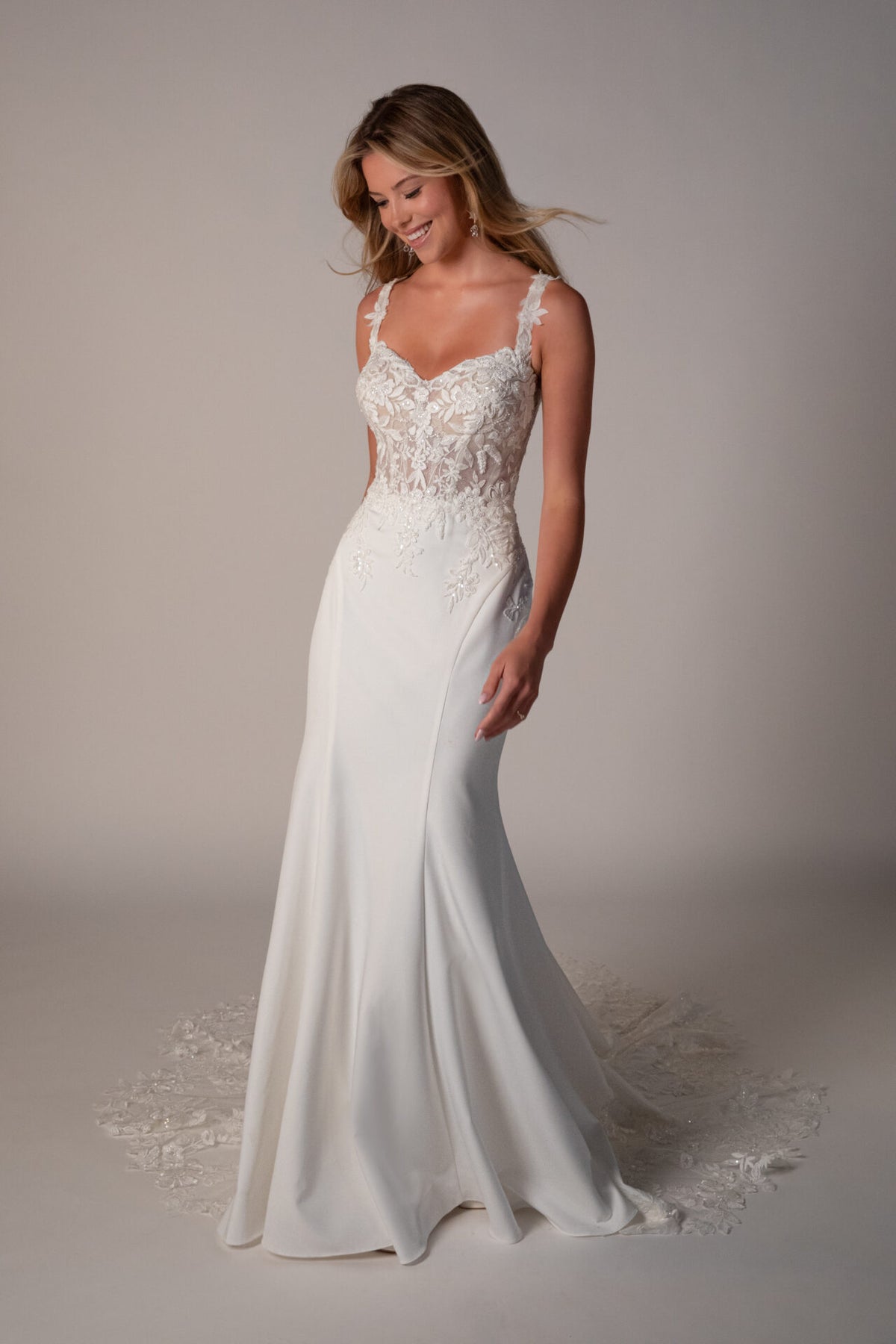 Stella York Luca wedding gown with intricate lace details and a flowing train, displayed on a mannequin.
