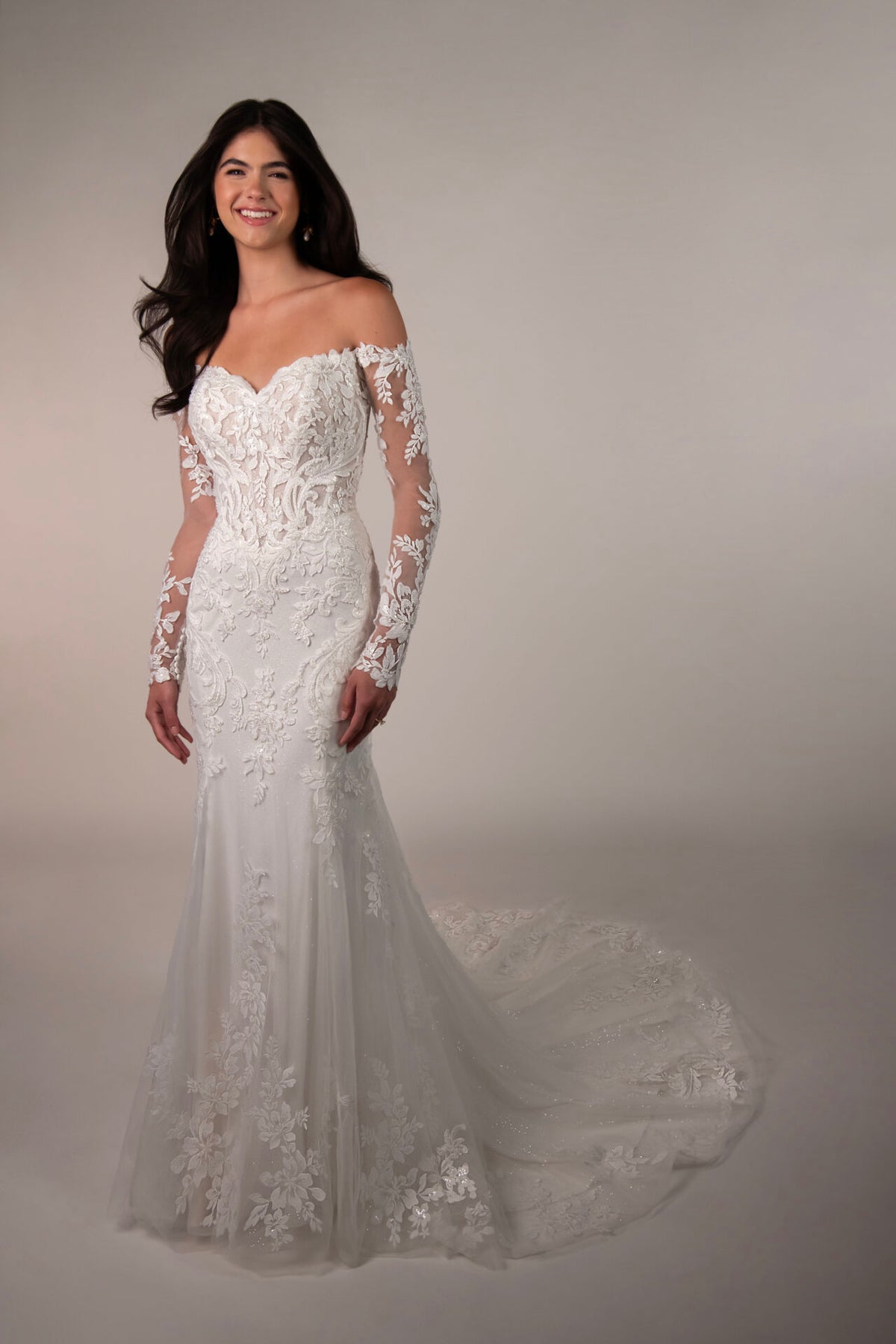 Stella York wedding gown with intricate lace details and a flowing train, displayed on a mannequin.