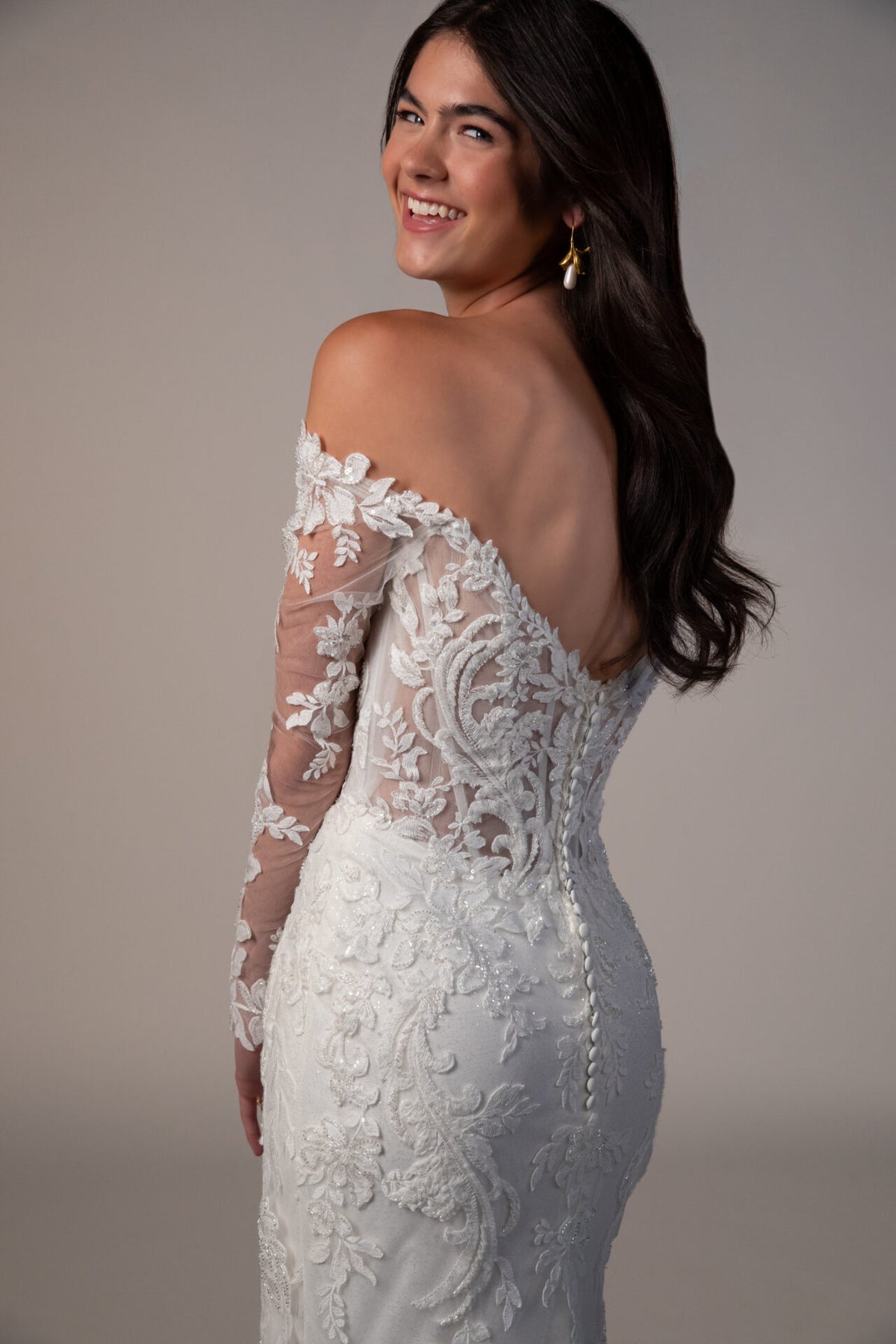 Stella York wedding gown by Mckinley with intricate lace detailing and a flowing train, displayed on a mannequin.