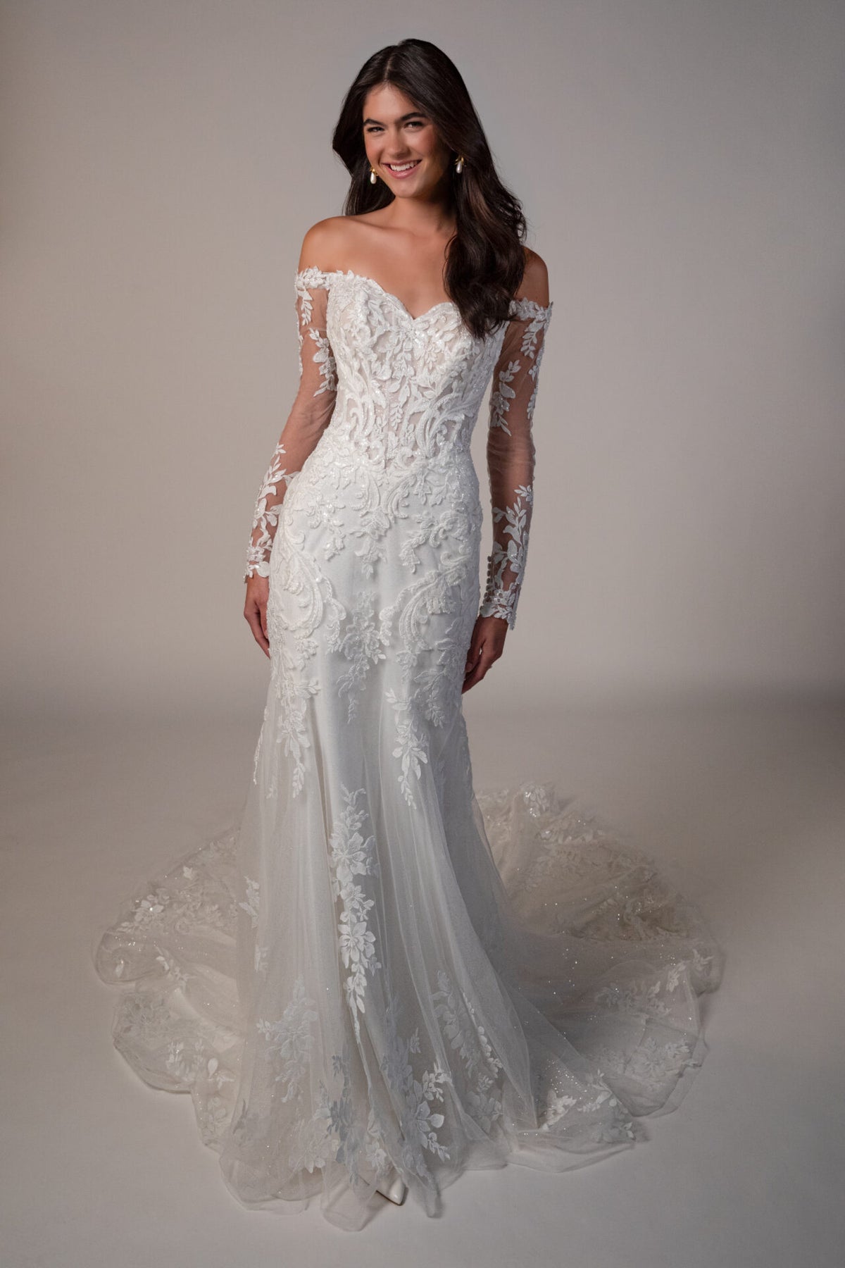 Stella York wedding gown with lace details, fitted bodice, and flowing train, displayed on a model for the Mckinley collection.