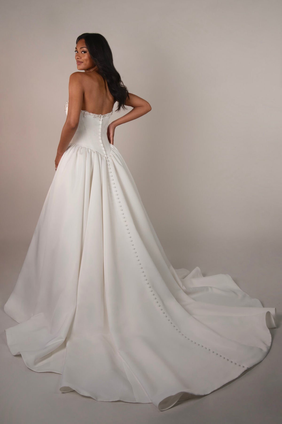 Stella York Mawson wedding gown with lace details and flowing train, arriving December, displayed on a mannequin.