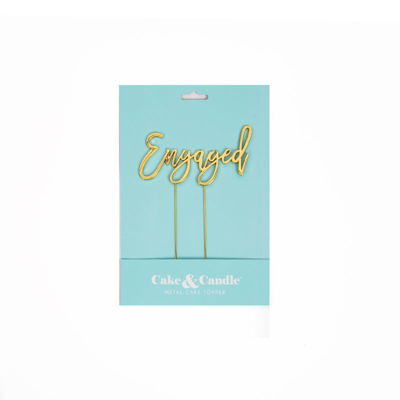 Gold "Engaged" cake topper from Cake and Candle giftware, featuring elegant script for wedding or engagement celebration.